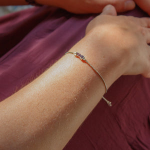 Close-up of a person's hands with a watch and bracelet on a textured surface