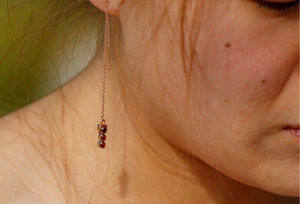 Close-up of a person wearing a delicate necklace with small beads.
