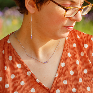 Person wearing an orange polka dot dress with a blurred outdoor background