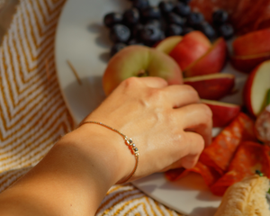 Person's hand reaching for fruit on a plate with a blurred background